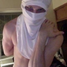 a shirtless man wearing a white head covering