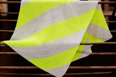 a yellow and white blanket sitting on top of a chair