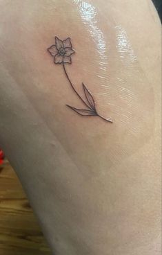 a small flower tattoo on the thigh