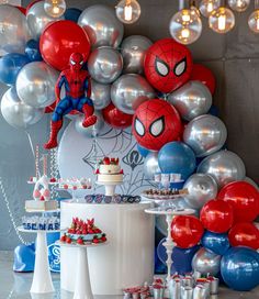 a spiderman themed birthday party with balloons and cake