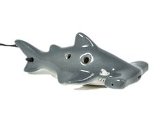 a gray plastic toy shark on a white background