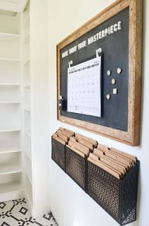 a chalkboard mounted to the side of a white wall next to a black and white tiled floor