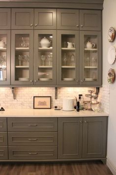 a kitchen with gray cabinets and white counter tops