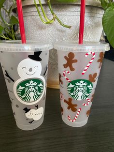 two starbucks cups decorated with christmas decorations and candy canes are sitting next to each other