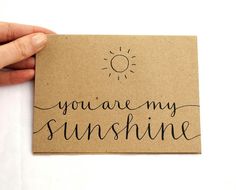 someone holding up a piece of paper with the words you are my sunshine on it