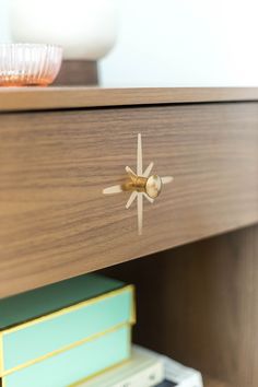 a close up of a drawer with some books on it and a bowl in the background