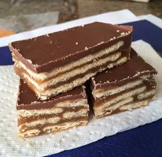 four pieces of cake sitting on top of a white towel next to a blue and white napkin