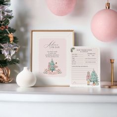 a christmas tree with pink ornaments and a baby's birth certificate next to it