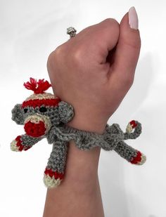 a crocheted sock monkey bracelet on someone's wrist