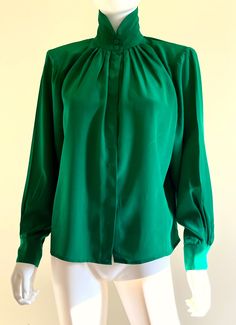 "Gorgeous vintage C1980s sumptuous, butter soft heavy silk long sleeved forest green blouse by Levante, featuring a nehru collar, front and back top pleats, and a front button closure under a hidden button placket. Approximate Measurements:        Chest, Waist, Hips: Up to 48\"; Length: 23\"        Labeled a size 6 Fabric:  100% silk Condition: Excellent, likely unworn, vintage condition." Green Long Sleeve Formal Blouse, Green Long Sleeve Blouse For Formal Occasions, Elegant Long Sleeve Green Blouse, Green Long Sleeve Top For Evening, Formal Green Blouse For Fall, Vintage Green Silk Top, Vintage Solid Blouse For Fall, Vintage Blouse For Fall, Vintage Green Formal Tops