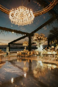 an indoor wedding venue with chandelier and tables