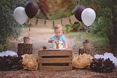 a baby boy sitting in front of a cake