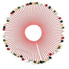 a circular object made out of red and white sticks with green, orange, yellow and black beads