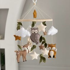 a mobile with animals and stars hanging from it's sides in a nursery room