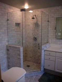 a bathroom with a walk in shower next to a white sink and counter top area