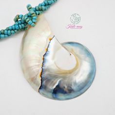 The White Nautilus shell is from Netherland and crafted in Indonesia. The Necklace is made of small Light blue Racine beads string together each bead to be a beading line and twist each line to be one line to stronger and look beautiful, and it is 18 inches long, weight 45g. (including pendant)   It's a real seashell from farming which it's fed by the seaweed, not from the natural environment due to environmental conservation. Our product was crafted with craftsmanship from one generation to one generation, and it may not last forever. Unlike a product that is made by machine. It's not just an ordinary necklace but it's about the taste of the wearer. It's for you or anyone who infatuates nature which each of the shells may look alike but not the same in color and texture. It's very UNIQUE. Ocean-inspired Blue Beaded Shell Necklace, Blue Beaded Shell Necklace Ocean-inspired, Turquoise Shell Beaded Necklaces, Blue Shell Jewelry With Colorful Beads, Turquoise Shell Beaded Necklaces With Round Beads, Ocean-inspired Shell Beaded Necklaces With Round Beads, Shell Beaded Necklaces For Jewelry Making, Gift Turquoise Beaded Shell, Turquoise Beaded Strand Shell