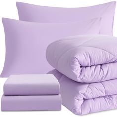 the comforter and pillows are all in lilac colors, with one pillow sitting on top of the bed