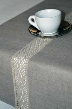 a white cup sitting on top of a table next to a saucer and spoon