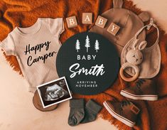 baby clothes and shoes are laid out on a blanket with the words happy camper