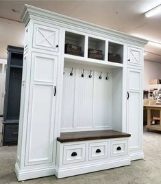 a large white mudroom with benches and hooks