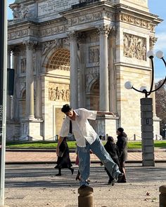 a man is doing tricks in front of the arc de trioe arch of triumph