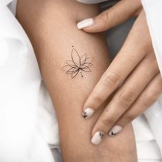 a woman's arm with a small flower tattoo on the left side of her body