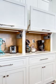 a kitchen with white cabinets and appliances on the counter top, along with a red rug