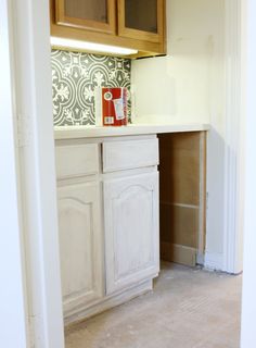 an empty kitchen with wooden cabinets and tile backsplashing on the wall behind it