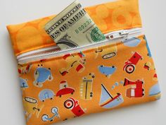 an orange wallet with money sticking out of it's pocket and on top of the other