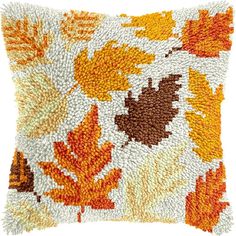 an orange and brown pillow with leaves on it