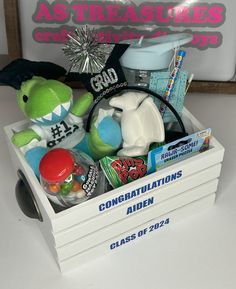 a white box filled with toys on top of a table in front of a sign