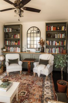 a living room filled with furniture and bookshelves covered in lots of bookcases