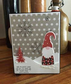 a christmas card with a gnome on it and snowflakes in the back ground