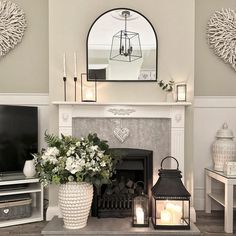 a living room filled with furniture and a fire place next to a tv mounted on a wall