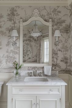 a bathroom with a sink, mirror and wallpaper