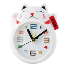 a white cat alarm clock with colorful numbers on it's face and eyes, sitting in front of a white background