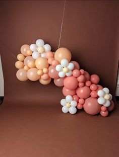 balloons are floating in the air next to a laptop computer on a brown tablecloth covered floor