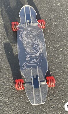 a skateboard with an image of a dragon on the bottom and red hands attached to it