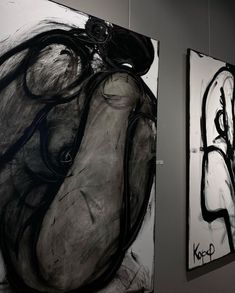 two black and white paintings hanging on the wall