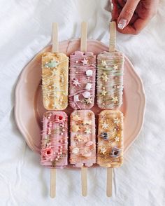 a pink plate topped with popsicles covered in candy