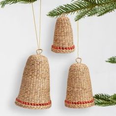 two christmas bells hanging from a pine tree with red bead trimming on them