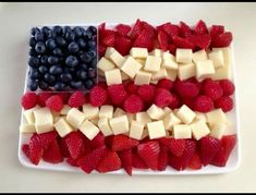 an american flag made out of cheese and strawberries on a white platter with blueberries