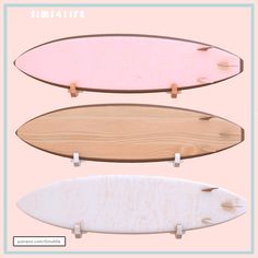 three surfboards are standing up against a pink background