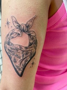 a woman's arm with a tattoo on it that has a heart in the shape of a bow