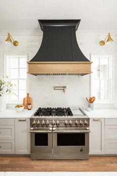 a stove top oven sitting inside of a kitchen next to white cabinets and counter tops