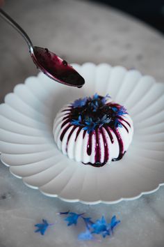 a white plate topped with a dessert covered in blue and red icing