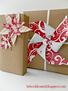 a wrapped present box with a paper flower on it and a gift wrapper attached to it