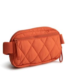 an orange quilted toiletry bag on a white background