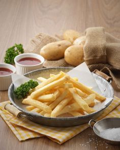 french fries and potatoes on a table with dipping sauces