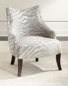 a zebra print chair sitting on top of a white rug